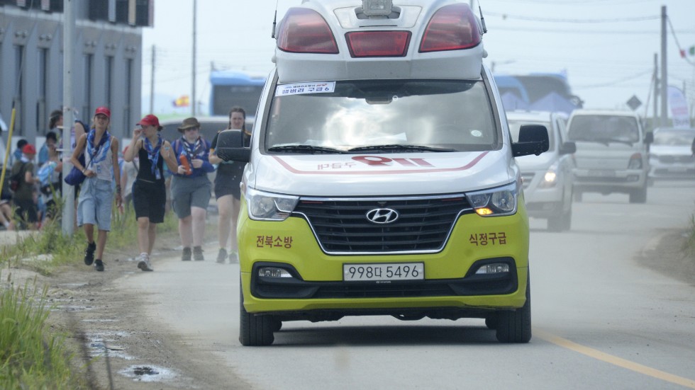 En ambulans lämnar scoutlägret i Saemangeum i Sydkorea under fredagen. Hundratals deltagare har fått vård på grund av extremvärmen.