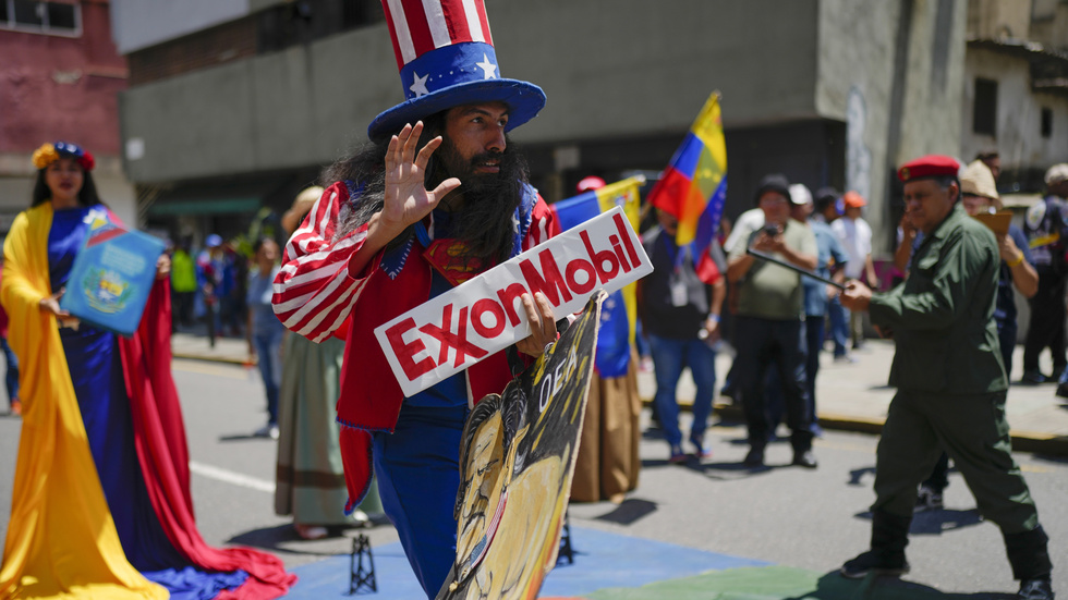 Demonstranter som förespråkar den venezuelanska regeringens linje i den kommande folkomröstningen. Mannen är utklädd till amerikanske "Uncle Sam" och håller en skylt med oljejätten Exxon Mobils logotyp. Arkivbild.