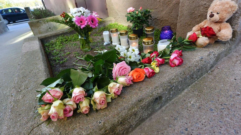 Karlskrona 2014: Blommor, ljus och en nalle utanför porten till det hus där den åttaåriga flickan som mördades bodde. Arkivbild.
