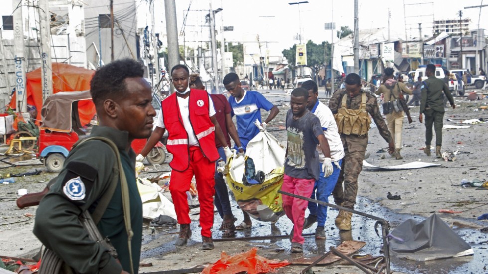 Kvarlevor lyfts bort vid den drabbade korsningen i centrala Mogadishu på lördagen.