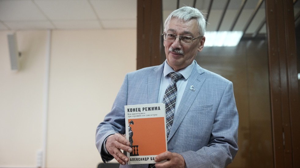 Oleg Orlov, medordförande i Memorials styrelse, visar upp en bok om auktoritära regimers fall i rättssalen i Moskva. Bilden togs den 8 juni.