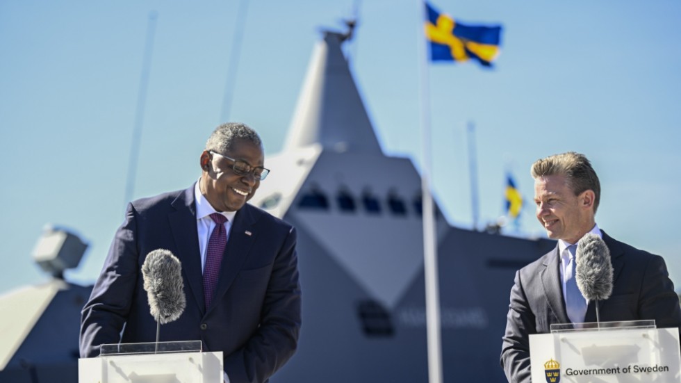 USA:s försvarsminister Lloyd J. Austin och försvarsminister Pål Jonsson (M) på Muskö örlogsbas. I bakgrunden HMS Härnösand, korvett av Visby-klass.