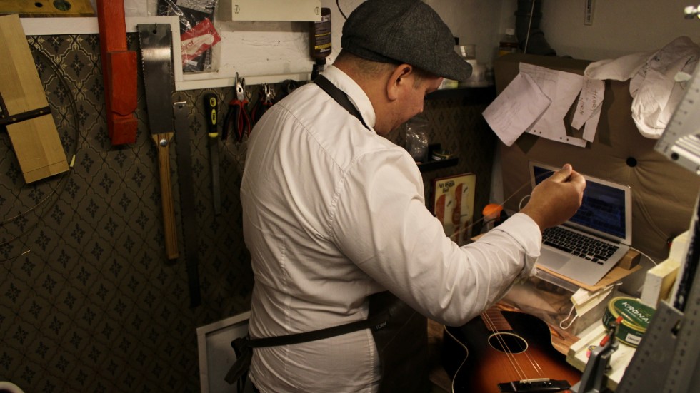 Richard Lang pysslar med en gitarr. Det är att byta strängar som står på schemat.