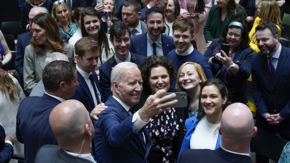 USA:s president Joe Biden tar en selfie med inbjudna gäster på Ulster University i Belfast.