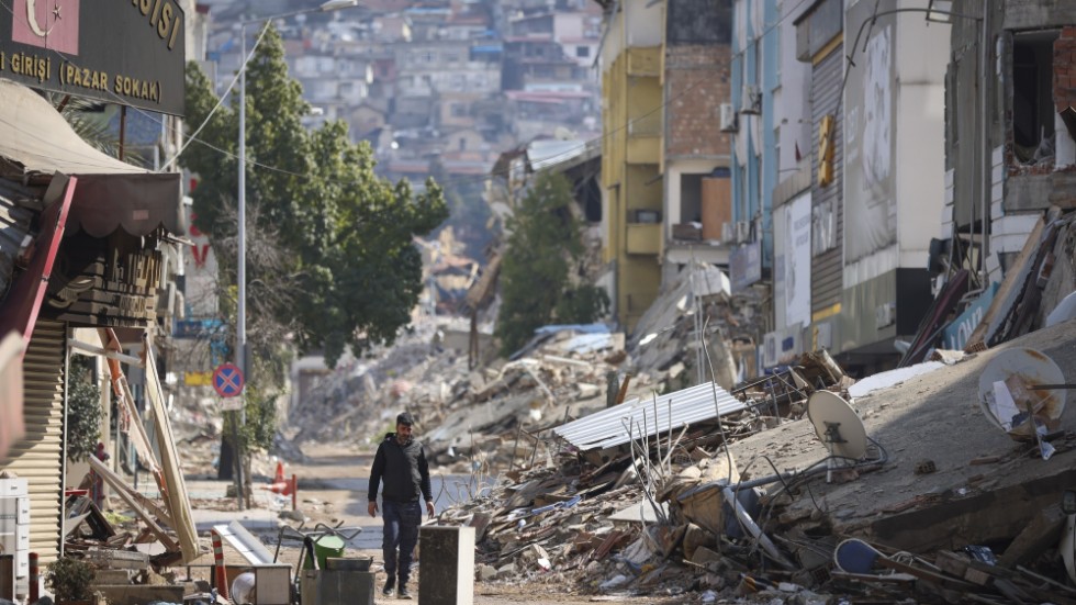En man bland förstörda byggnader i den turkiska staden Antakya.