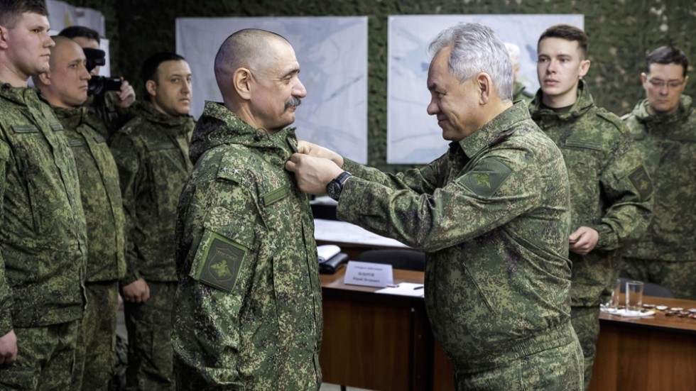 Rysslands försvarsminister Sergej Sjojgu, till höger främst i bild, sätter en medalj på en officerare i en anläggning någonstans i Ukraina. Bilden har distribuerats av det ryska försvarsdepartementet.