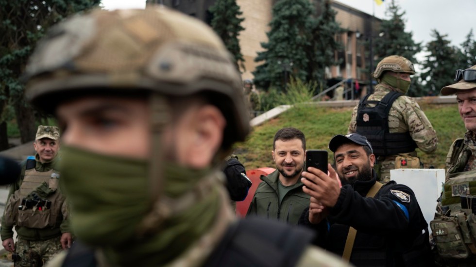 President Zelenskyj låter sig fotograferas med en polis i Izium på onsdagen.