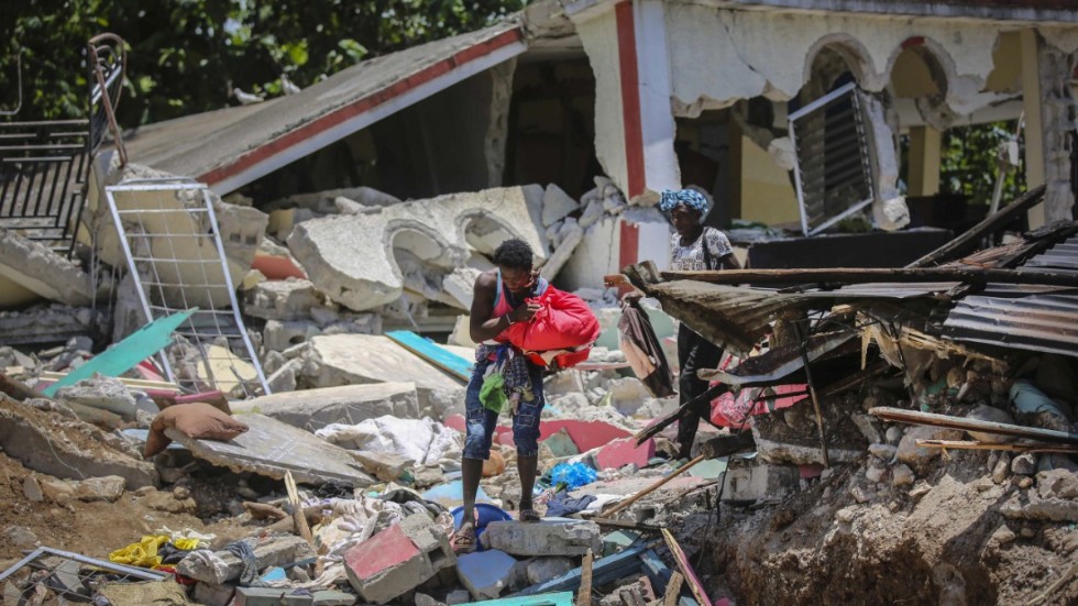 En överlevande försöker rädda vad som finns kvar av hemmet i Les Cayes.