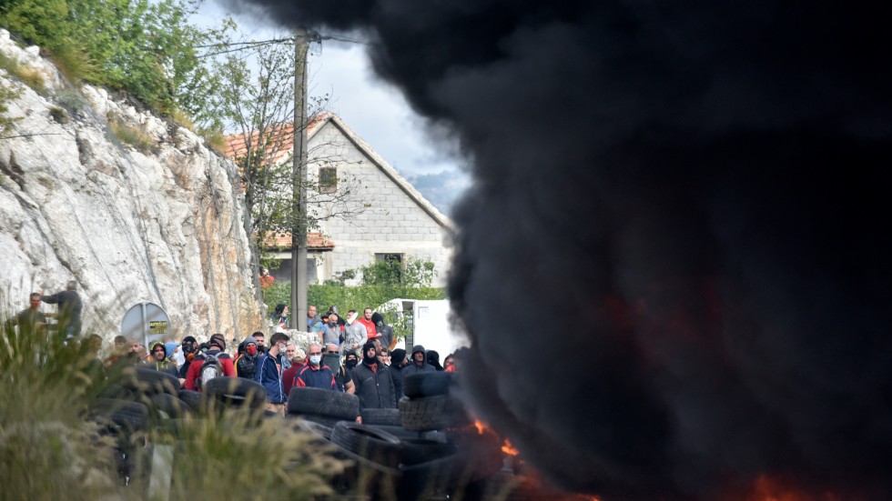Demonstranter sätter eld på bildäck vid en vägspärr vid staden Cetinje i Montenegro där en ny biskop installeras och säkerhetspådraget är stort.