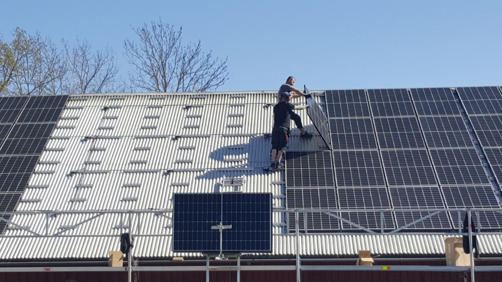 Emil Rikardsson och Jano Suliman på företaget Solortus monterar solceller på ett stalltak.