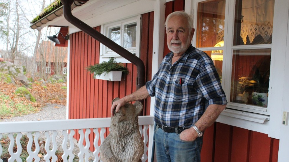 Bo Karlsson på förstutrappan till det hus i Humpen som han och hustrun byggt och byggt ut under de senaste 50 åren. Björnen är en gåva från ett av barnen. 