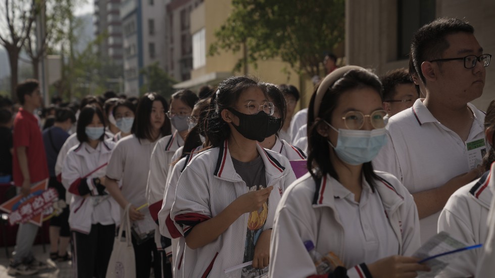 Unga kineser köar för att göra det stora och viktiga inträdesprovet, utanför en skola i Peking på onsdagsmorgonen.