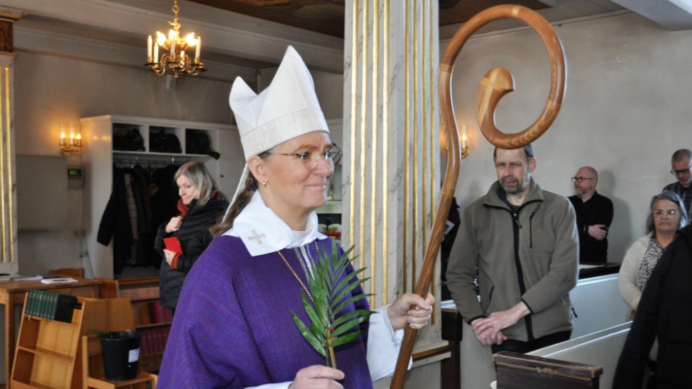 Biskop Marika Markovits äntrar Kisa kyrka med ett palmblad i sin hand till tonerna av Te Deum Trumpet Tune framförd av Horns musikkår.