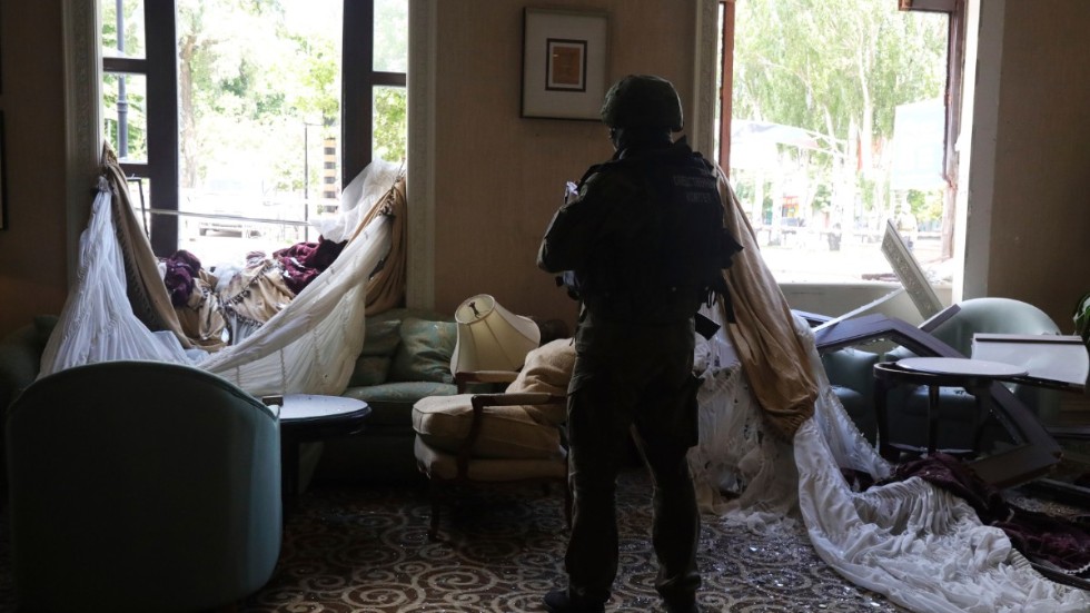 En undersökningsofficer granskar förödelsen efter beskjutning mot Donetsk i östra Ukraina. Bilden togs 4 augusti.  