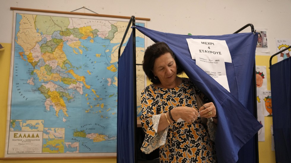 En kvinna lämnar valbåset efter att ha röstat i Aten.