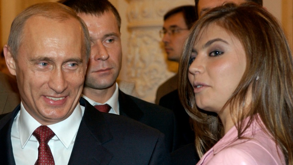 Vladimir Putin i samspråk med Alina Kabajeva på en bankett i Kreml i november 2004. Några år senare började ryktena om deras romans att florera. Arkivbild.