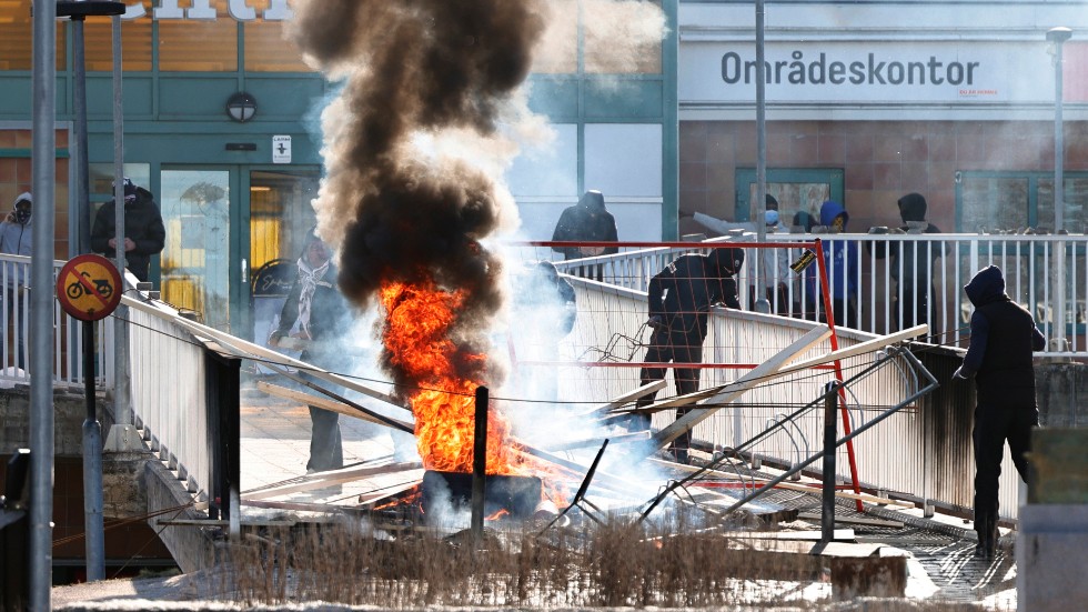 Personer gör en barrikad med brinnande bildäck och andra föremål i Norrköping på påskdagen, den 17 april 2022.
