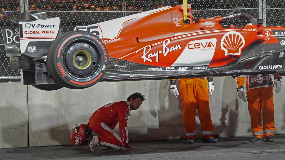 Ferrari-föraren Carlos Sainz inspekterar sin skadade bil efter träningen i torsdags.