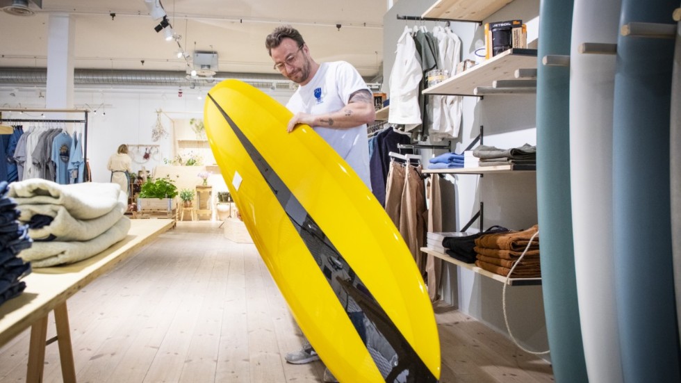 Johan Orrestedt visar upp en av de surfbrädor som finns att köpa i butiken. 