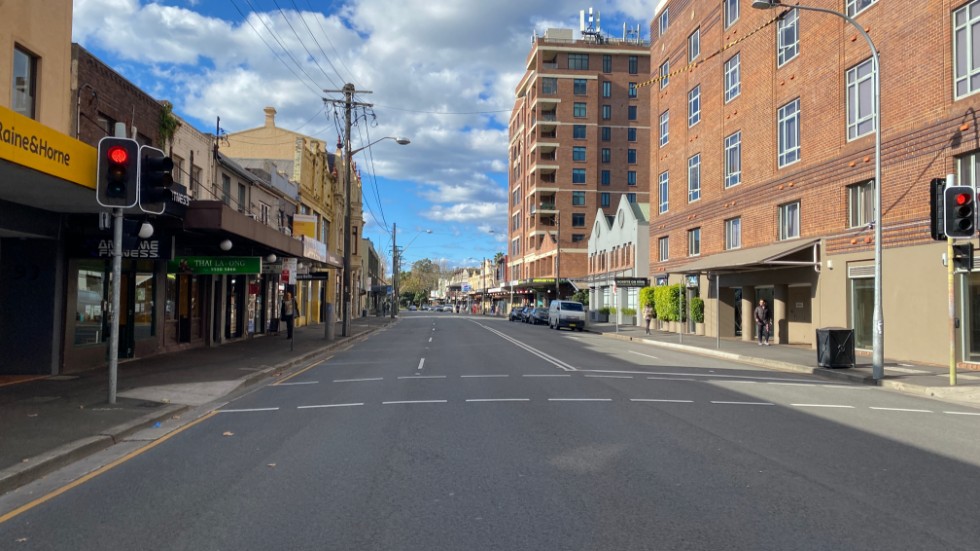 Den vanligtvis livliga gatan King Street i Newtown i Sydney är nästintill öde till följd av nedstängningen av den australiska storstaden.
