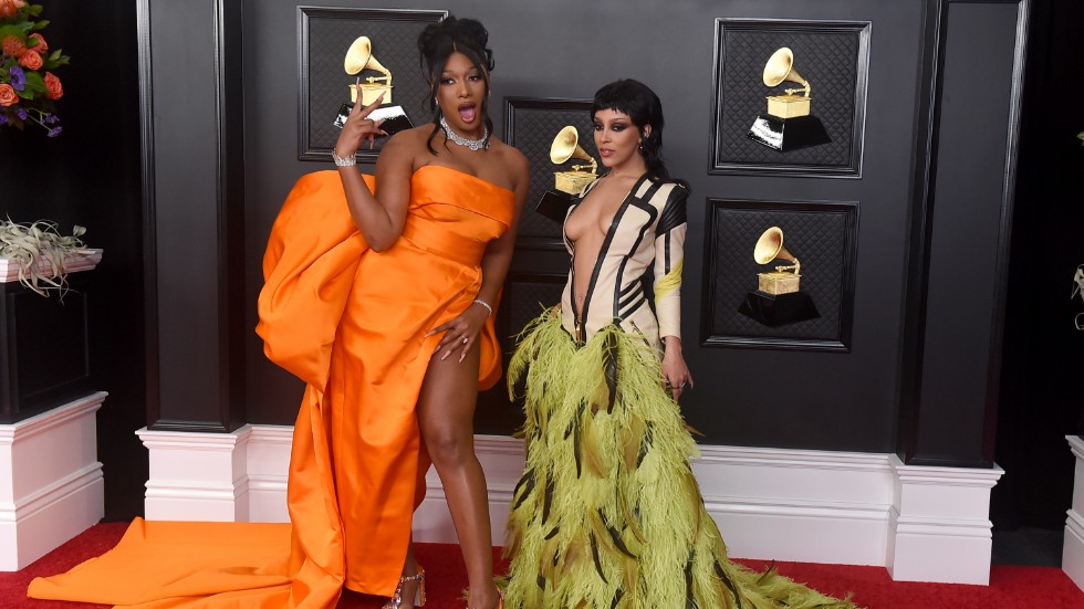 Megan Thee Stallion, i orange klänning, vann en Grammy för Årets rapframträdande. Här är stjärnan på väg in till galan i Los Angeles, tillsammans med Doja Cat.