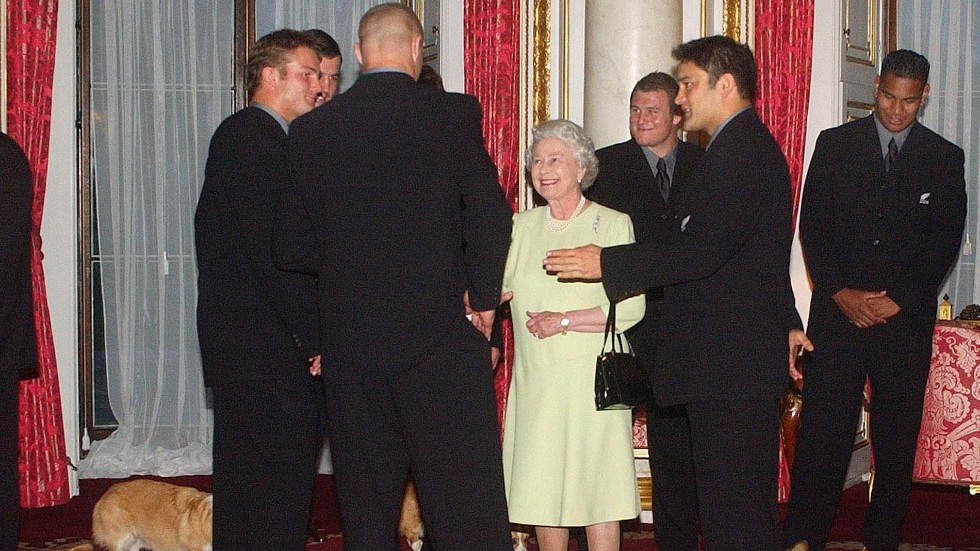Drottning Elizabeth tar emot det nyzeeländska rugbylandslaget All Blacks år 2003 – och drottningens corgis var naturligtvis med vid tillfället. Arkivbild.