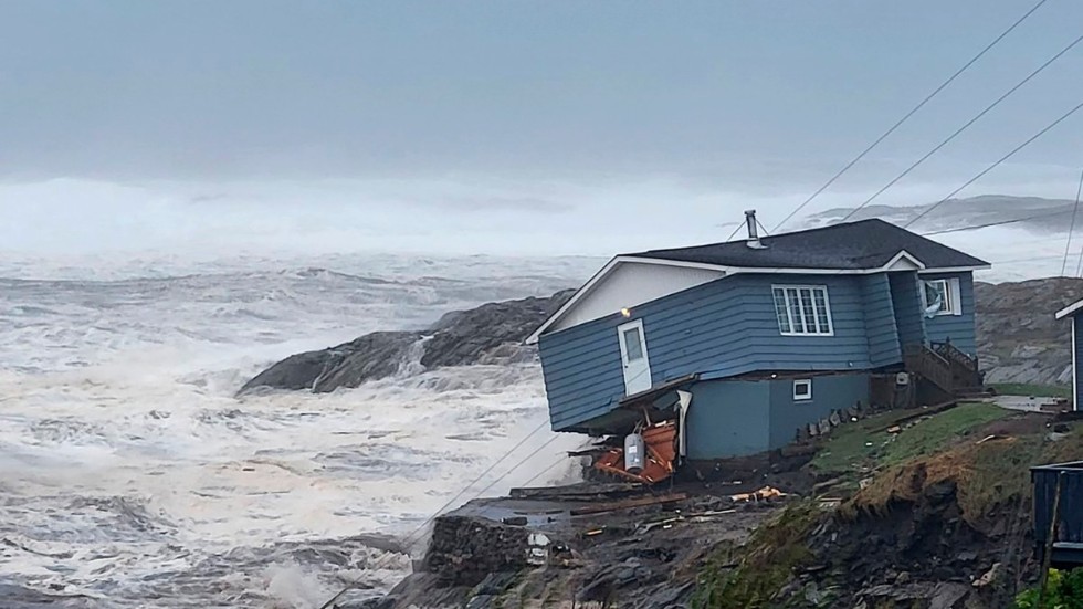 Ett hus vid kusten i Port aux Basques, Newfoundland, strax innan det sveptes ut i havet.