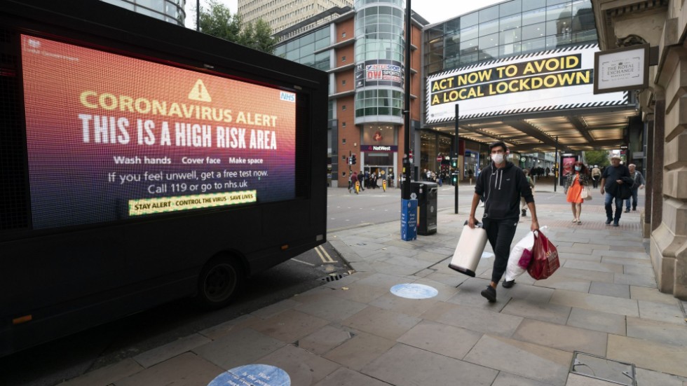 Varningsskyltar bland handlande människor i centrala Manchester i norra England i tisdags.