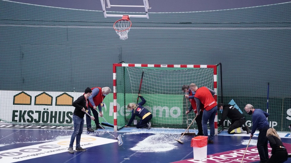 Funktionärer sopar upp glas efter att basketkorgen krossades innan lördagens landskamp i handboll mellan Sverige och Ungern.