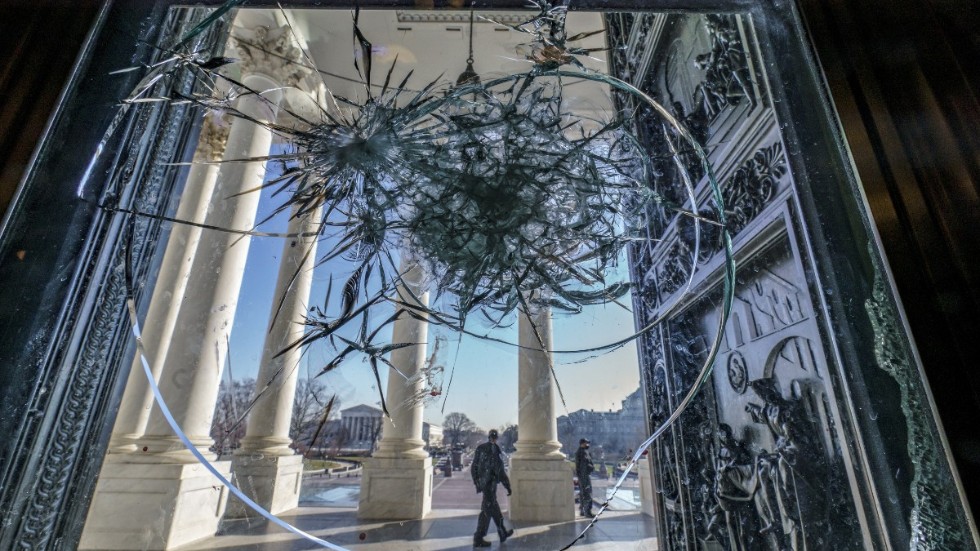 En krossad glasruta i Kapitolium påminner om förra veckans stormning.