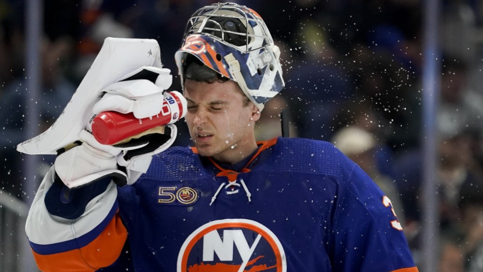 New York Islanders målvakt Ilja Sorokin svalkar sig. Puckarna ven runt den ryske målvakten.