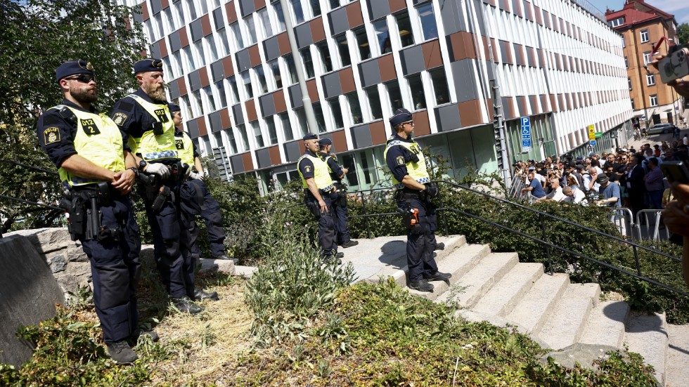Poliser vid avspärrningarna under koranbränningen i Stockholm i juni. Bränningen av en tora och en bibel uppges vara ett svar på den händelsen. Arkivbild.