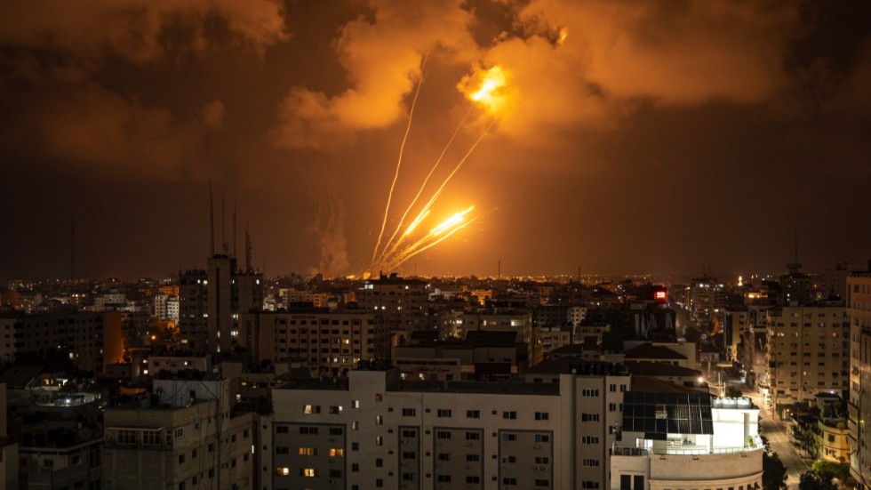 Raketer som avfyras mot Israel lyser upp kvällshimlen i staden Gaza.