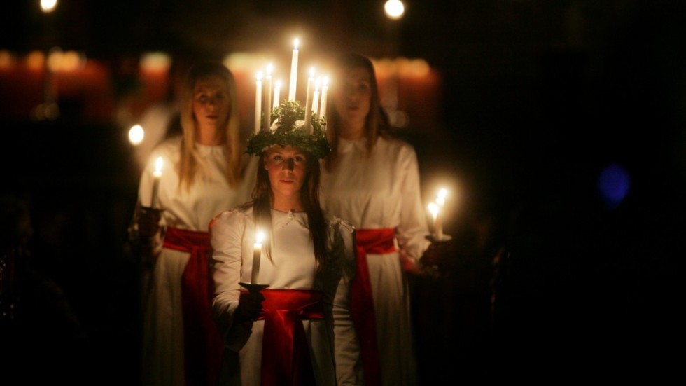 Lucia i Sverige har en symbolisk ljuskrans på huvudet och kaffebricka i händerna till minne av Lucia från Syrakusas goda gärningar. 