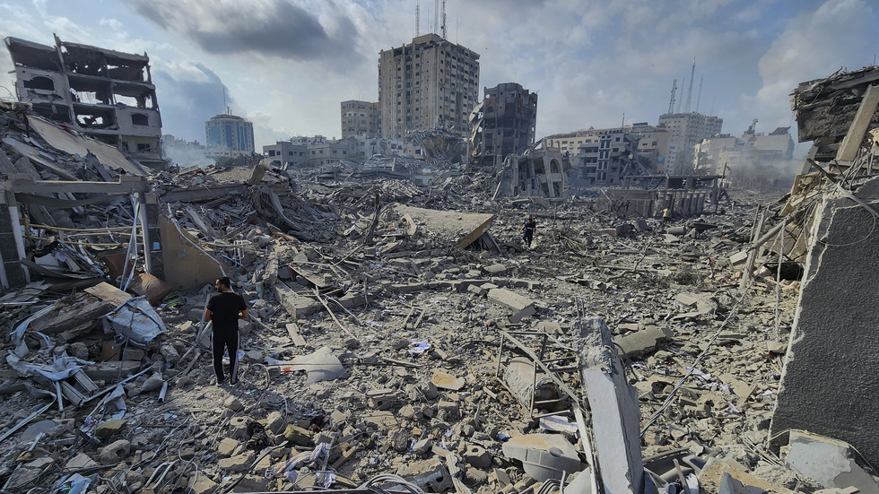 Palestinier går omkring i de rasmassor som återstår av byggnader som bombades sönder i staden Gaza den 10 oktober. Arkivbild.