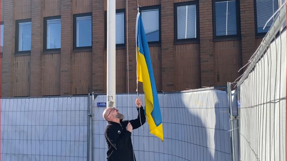 Här hissas ukrainska flaggan vid stadshuset i Vimmerby. Vaktmästare Janne Carlson berättar att han lyckades köpa en av de sista hos ett företag i Skåne.