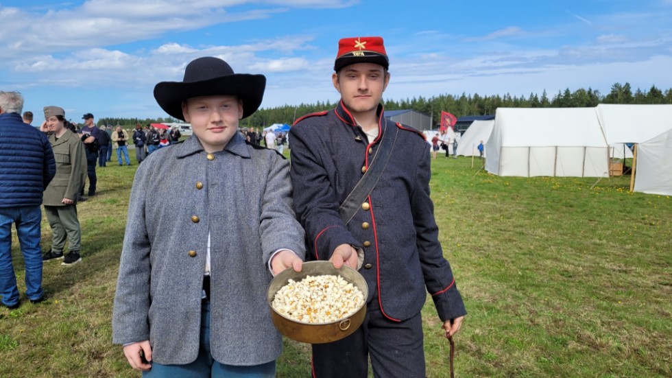 Tolvåriga Sebastian Gelin och femtonåriga Otto Wilensjö går runt och bjuder på popcorn på Mommehål under den militärhistoriska träffen.
