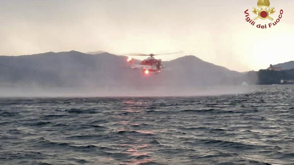 En bild från räddningstjänsten visar en helikopter under sökarbetet efter att en turistbåt kapsejsat på sjön Maggiore i norra Italien på söndagen.