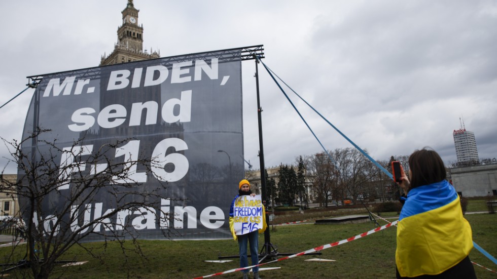 Demonstranter iklädda ukrainska flaggor vädjar om amerikanska stridsflygplan till Ukraina under USA:s president Joe Bidens besök i Polen i februari.