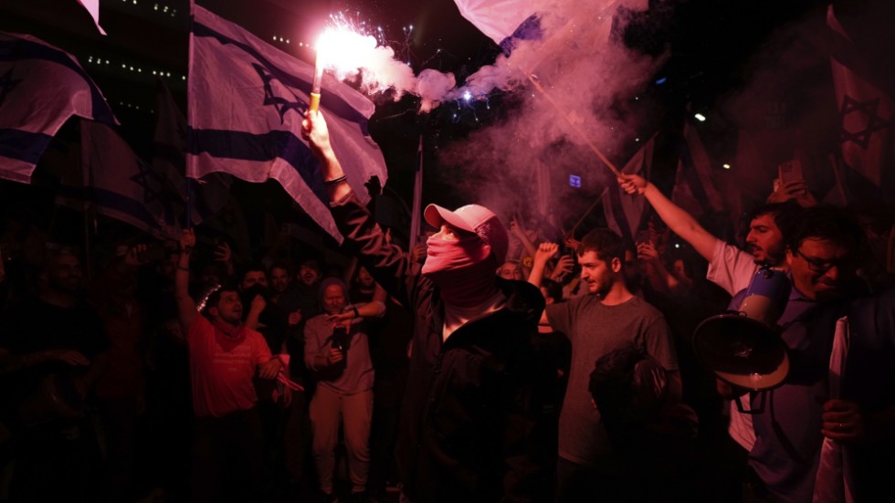 Israeler blockerar en motorväg i Tel Aviv-trakten under protesterna natten till måndagen.