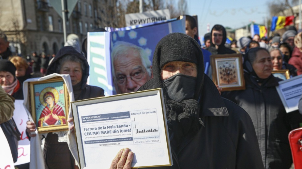 En äldre kvinna håller upp en inramad elräkning under en regeringskritisk protest arrangerad av den proryska oligarken Ilan Shors parti. Bilden togs i Chisinau i Moldavien den 12 mars.