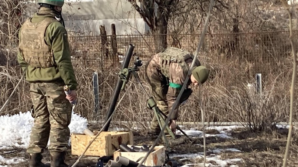 Ukrainska soldater i Bachmut riggar en granatkastare riktad mot fienden en dryg kilometer bort. 