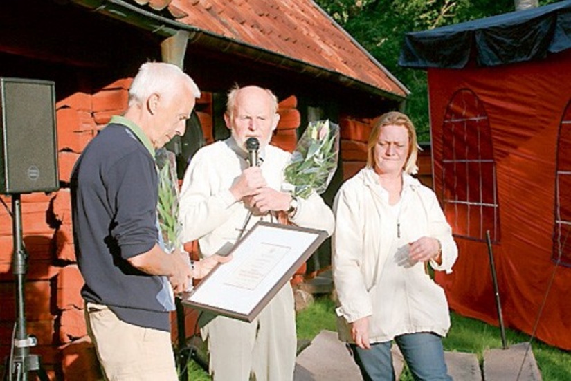 Ulf Brushane tar emot diplom, blommor och guldnål.