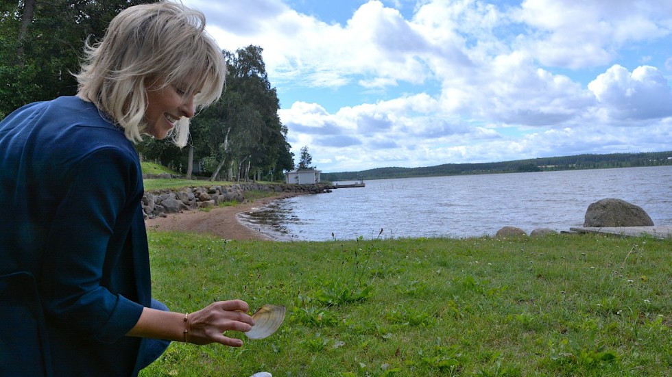 Karin Andersson har samlat musselskal i en hög vid en buske nära stranden. "Ja jag plockar alltid upp dom om jag ser dom. Jag gick här och plockade snäckskal som barn", berättar hon.