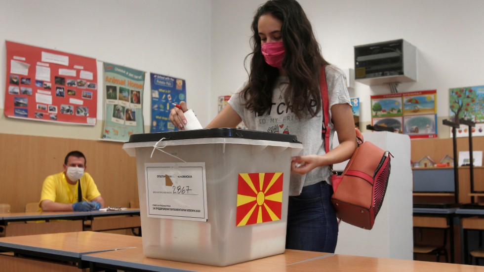 En väljare med munskydd lägger sin röst i det nordmakedonska parlamentsvalet i Skopje.