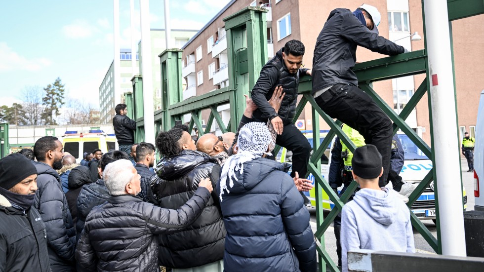 Människor i Rinkeby försökte lugna upprörda män och få dem att klättra ner från ett stängsel.