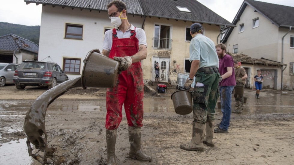 Frivilliga i Altenahr i Tyskland bildar en mänsklig kedja och langar undan lera och vatten.