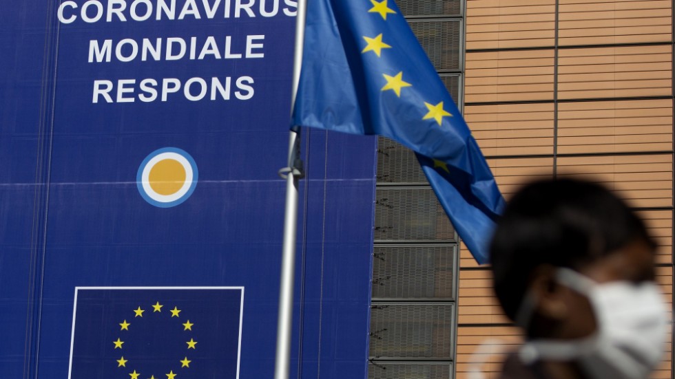 En kvinna med andningsskydd passerar EU-högkvarteret i Bryssel. Arkivbild.