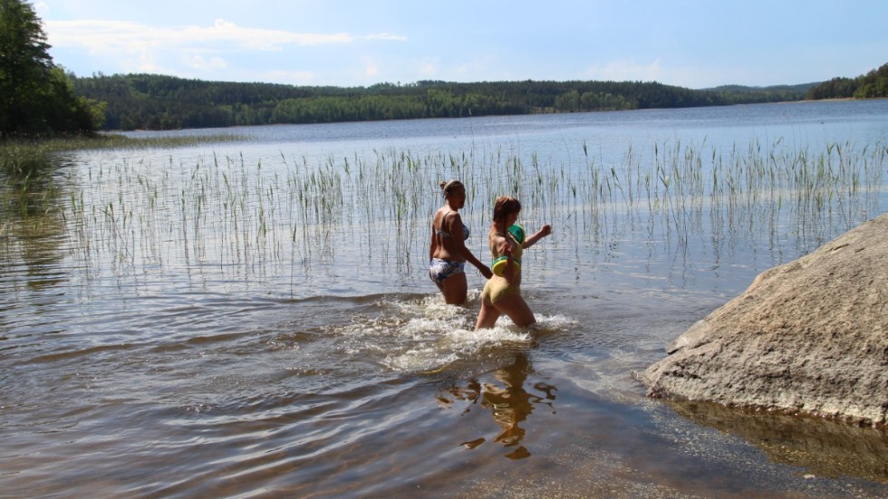 Två badsugna går med bestämda steg ut i sjön Föllingen för att svalka sig. 