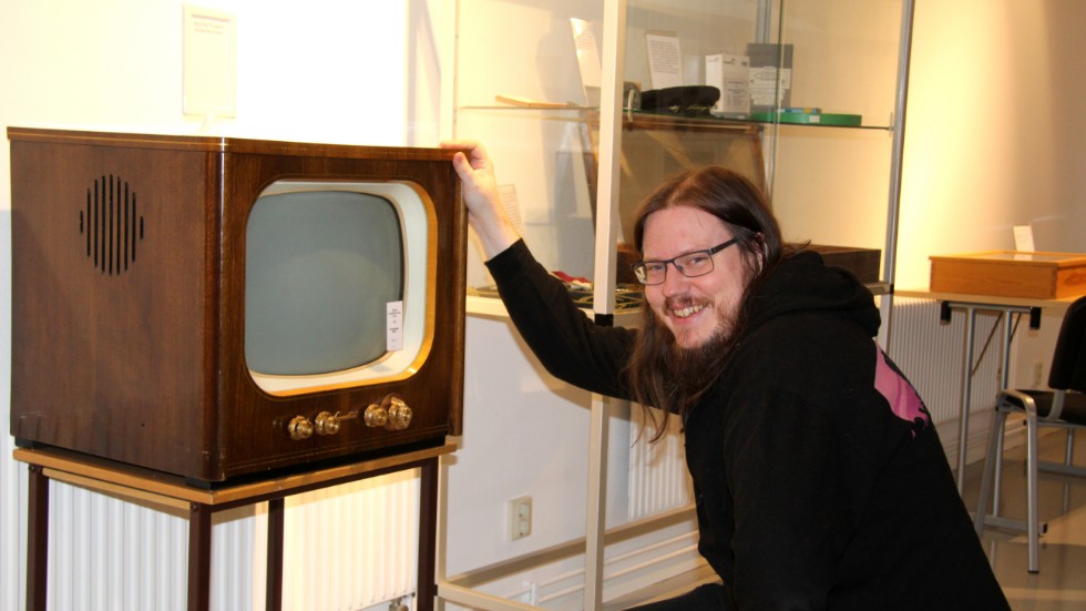 Kindas kulturhandläggare Emil Thuresson visar stolt upp Kisas första tv, som är en del av samlingarna i Kindas lokalhistoriska arkiv.